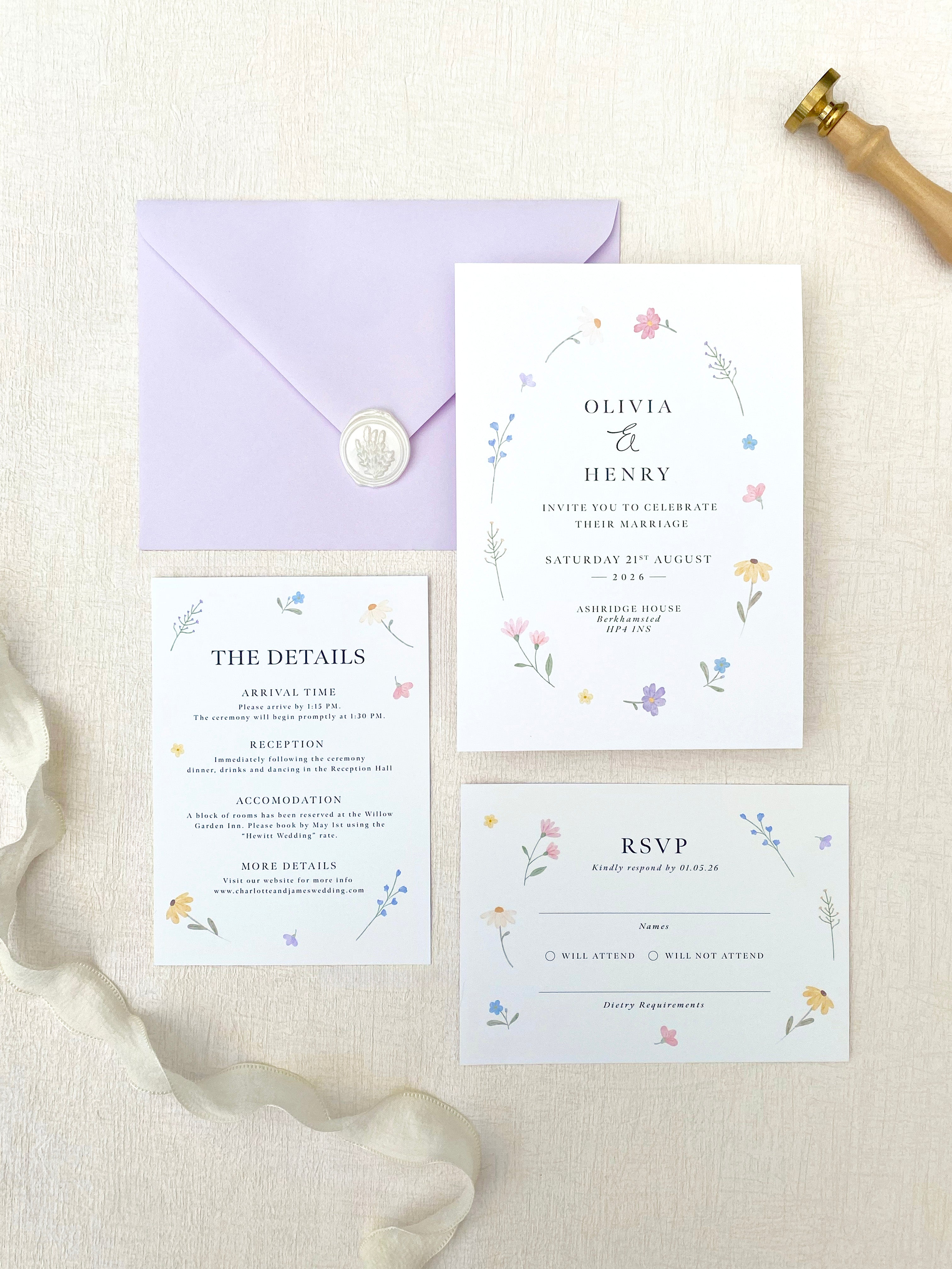 Wildflower Wedding invitation set with RSVP card, details card, and envelope on a textured surface.