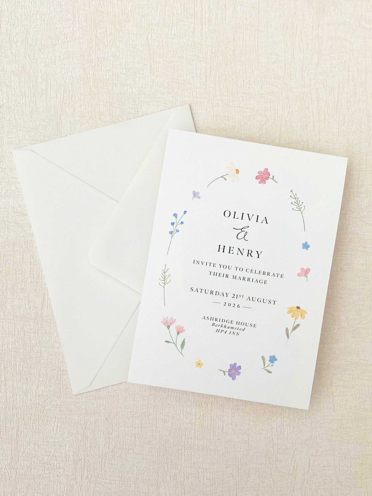 Wedding invitation with floral design on a beige background