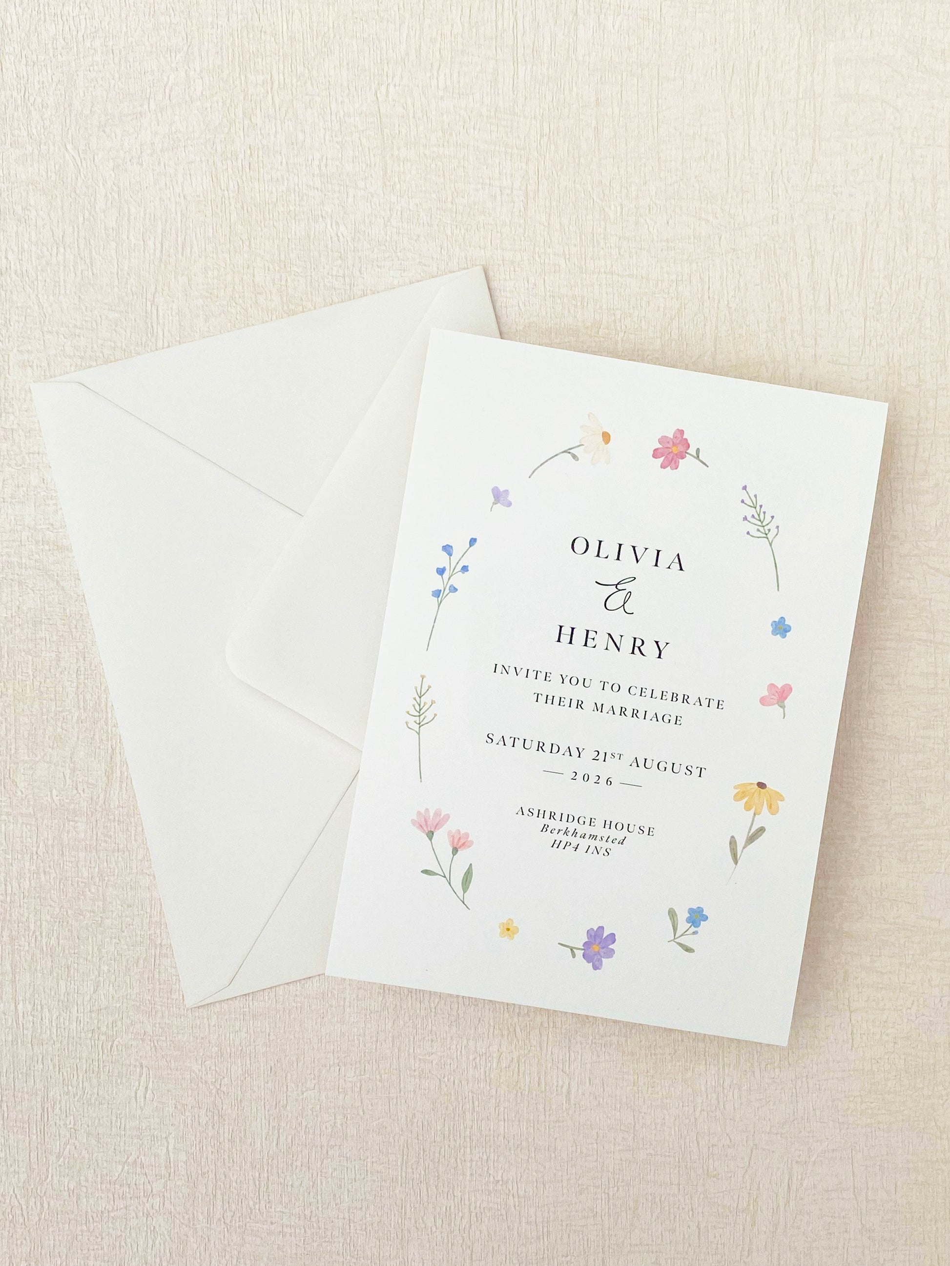 Wedding invitation with floral design on a beige background