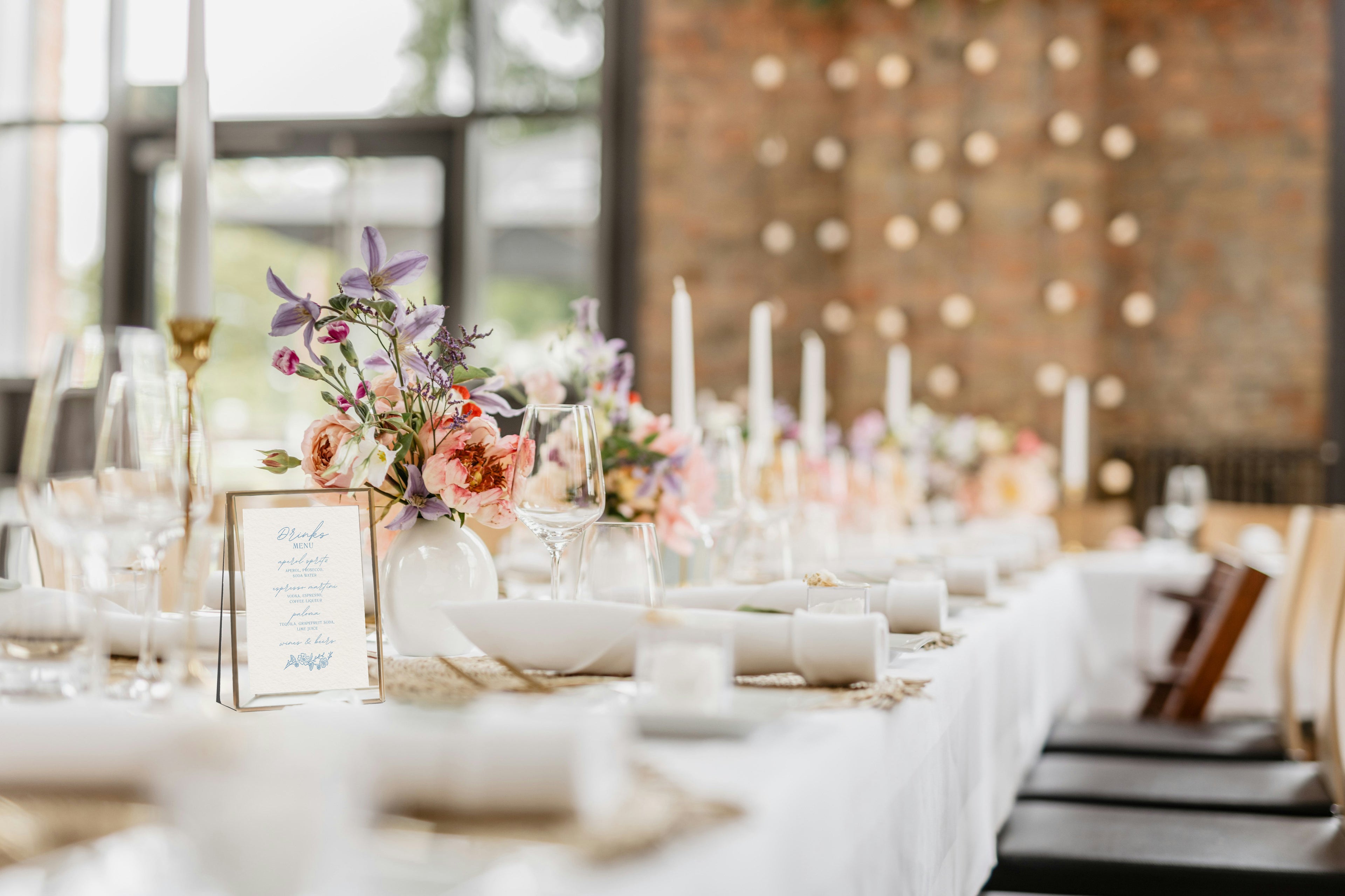Decorated table with floral centerpieces and candles in a rustic setting